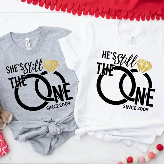 Two shirts with 'She's Still The One Since 2009' and 'He's Still The One Since 2009' text on a white background.