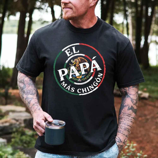 May include bold distressed text that reads “El Papá Más Chingón” over a circular Mexican flag-inspired design with an eagle emblem, celebrating proud and confident fatherhood with cultural pride.