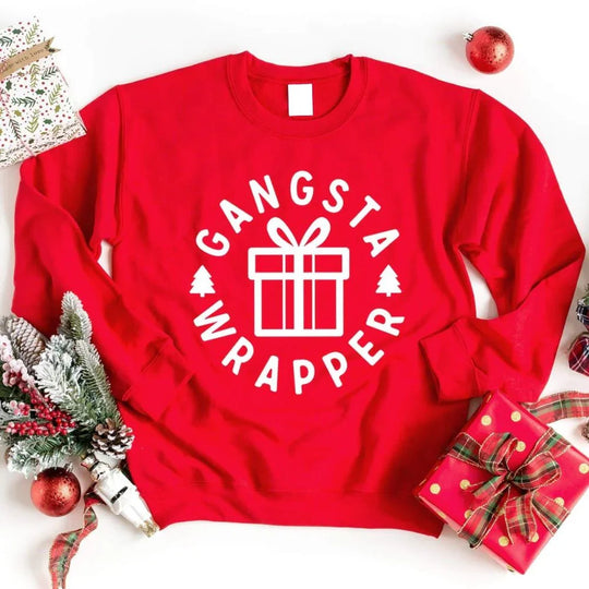 May include a red Christmas sweatshirt with a festive “Gangsta Wrapper” graphic featuring holiday icons and humorous design elements.