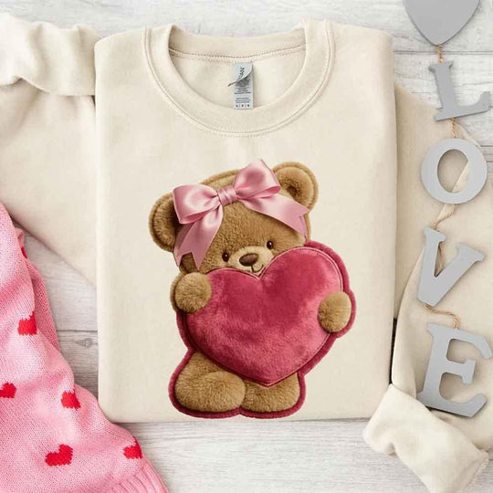 May include a crewneck sweatshirt with a plush teddy Valentine design featuring a furry-look 3D printed effect.