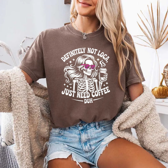 May include a short sleeve graphic tee featuring the phrase “Definitely Not Loca” on a casual unisex shirt.