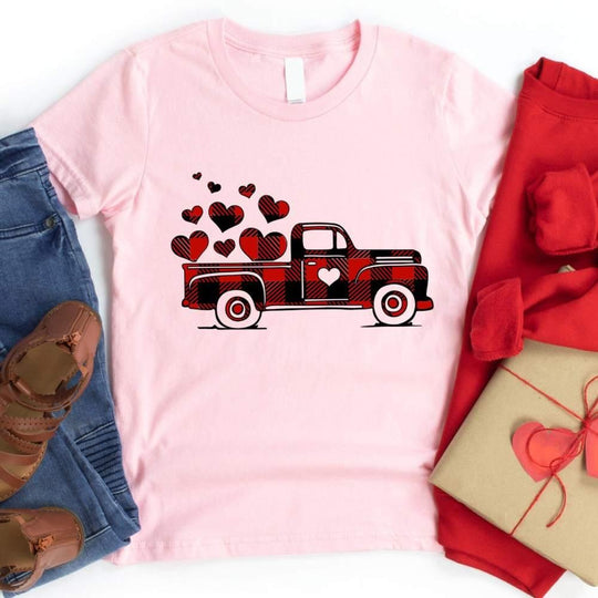 May include a graphic t-shirt featuring a vintage truck with a heart and buffalo plaid accents.