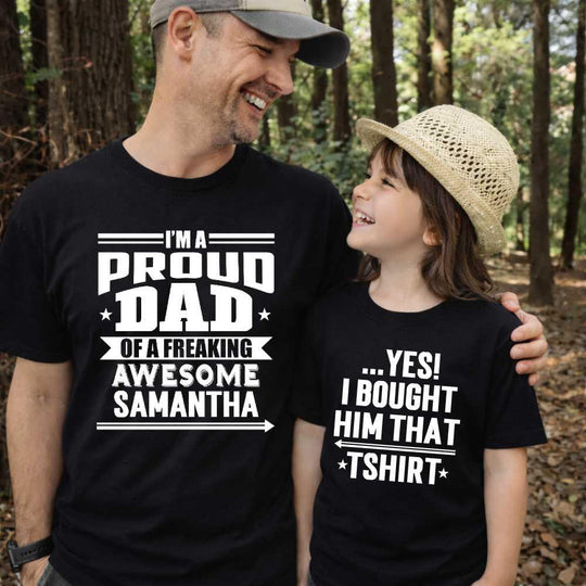 May include a father and child wearing matching t-shirts reading “I’m A Proud Dad” and “Me”
