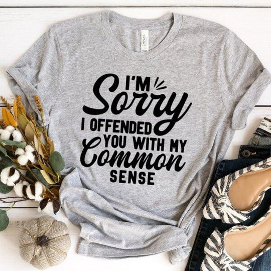 Gray custom t-shirt with 'I'm sorry I offended you with my common sense' text, flat lay with fall decor.