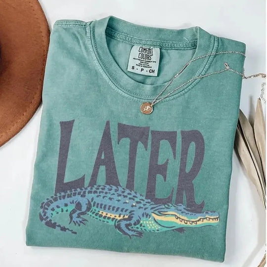 May include a Comfort Colors Later Gator vintage 90s t-shirt featuring a retro crocodile graphic and washed garment-dyed fabric.