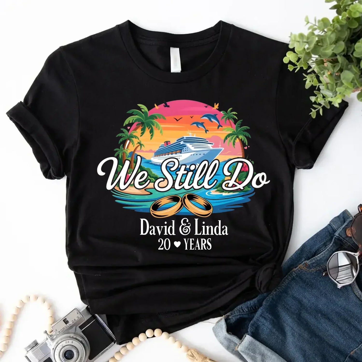 Black custom anniversary t-shirt with cruise ship, tropical sunset, palm trees, wedding rings, and We Still Do text.