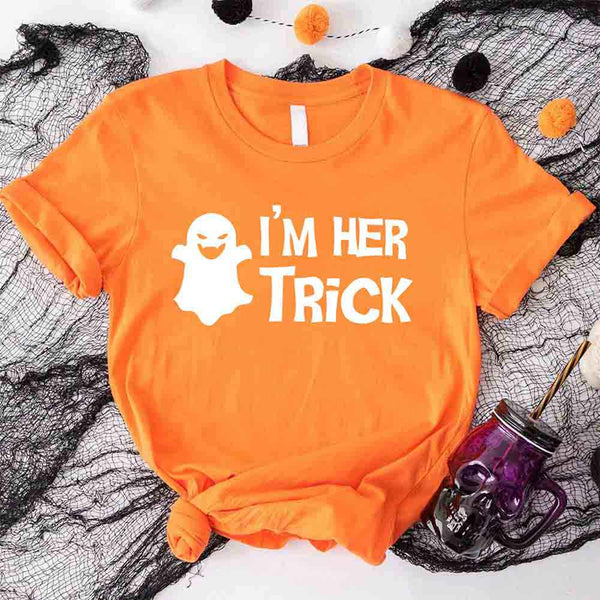 May include matching couple Halloween shirts with bold white text, one reading ‘I’m Her Trick’ with ghost graphic on orange tee, and the other reading ‘I’m His Treat’ with witch silhouette on black tee – funny spooky couple apparel.