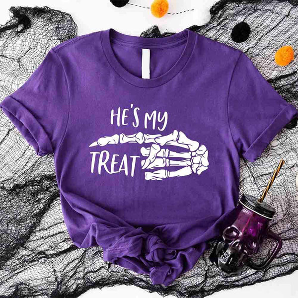 May include matching couple Halloween shirts with skeleton hand graphics, one reading ‘She’s My Trick’ on orange tee and the other reading ‘He’s My Treat’ on black tee – funny spooky couple apparel.