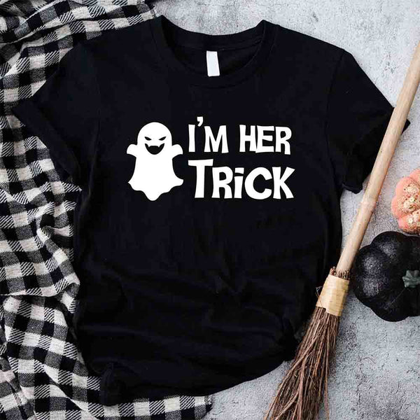 May include matching couple Halloween shirts with bold white text, one reading ‘I’m Her Trick’ with ghost graphic on orange tee, and the other reading ‘I’m His Treat’ with witch silhouette on black tee – funny spooky couple apparel.