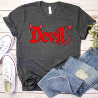 Gray t-shirt with 'Devil' in red on a wooden surface with jeans and shoes.