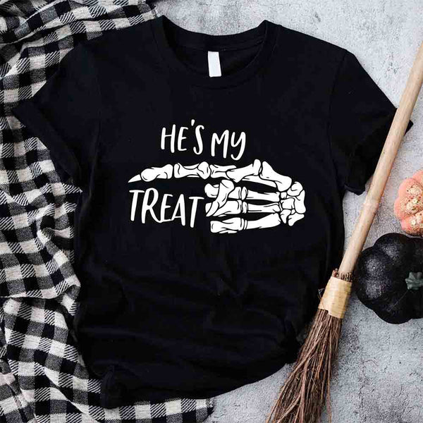 May include matching couple Halloween shirts with skeleton hand graphics, one reading ‘She’s My Trick’ on orange tee and the other reading ‘He’s My Treat’ on black tee – funny spooky couple apparel.
