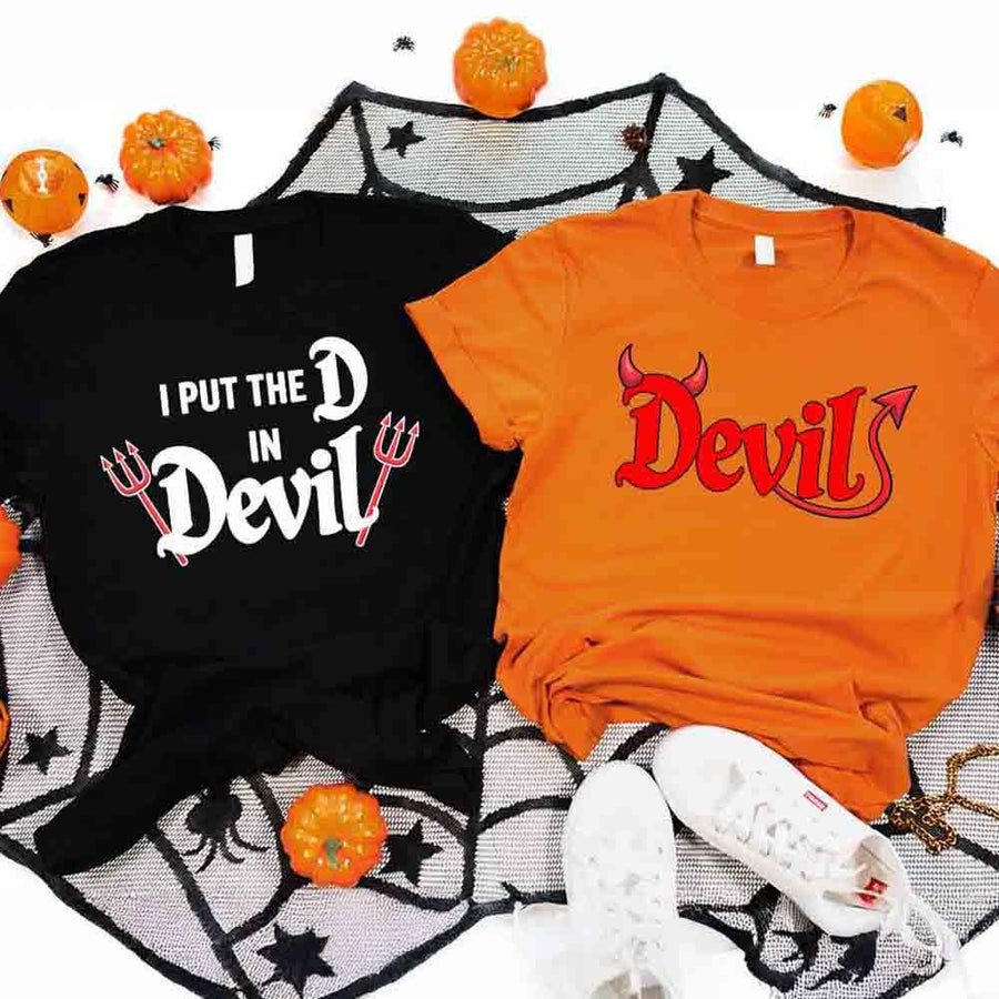 May include matching couple Halloween shirts, one with text ‘I Put the D in Devil’ in white with pitchfork graphic, and the other with bold red ‘Devil’ text featuring horns and tail – funny spooky couple tees.