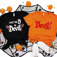 May include matching couple Halloween shirts, one with text ‘I Put the D in Devil’ in white with pitchfork graphic, and the other with bold red ‘Devil’ text featuring horns and tail – funny spooky couple tees.