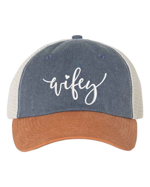 May include an embroidered pigment-dyed trucker hat with mesh back, featuring “Wifey” or “Hubby” text, designed as a casual and stylish gift for spouses or anniversaries.