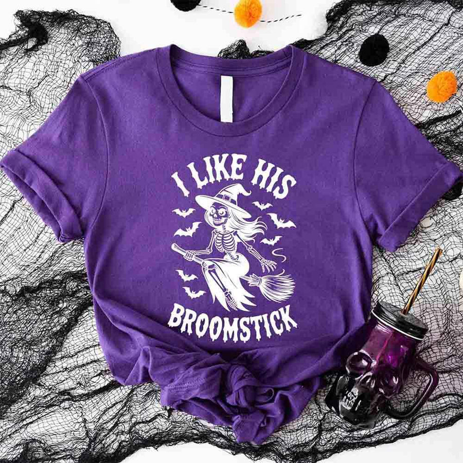 Purple t-shirt with skeleton design and text on a Halloween-themed background