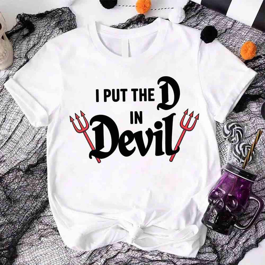 White t-shirt with 'I Put the D in Devil' text on a Halloween-themed background