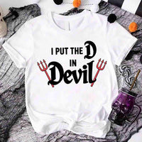 White t-shirt with 'I Put the D in Devil' text on a Halloween-themed background