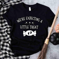 May include matching couple Halloween pregnancy announcement shirts, one reading ‘We’re Expecting a Little Treat’ with candy and baby footprints, and the other reading ‘It’s Not Trick’ with candy graphic – fun maternity reveal apparel.