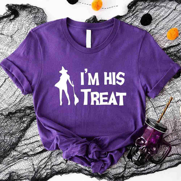May include matching couple Halloween shirts with bold white text, one reading ‘I’m Her Trick’ with ghost graphic on orange tee, and the other reading ‘I’m His Treat’ with witch silhouette on black tee – funny spooky couple apparel.