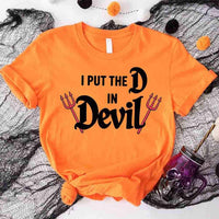Orange t-shirt with 'I Put the D in Devil' text on a Halloween-themed background