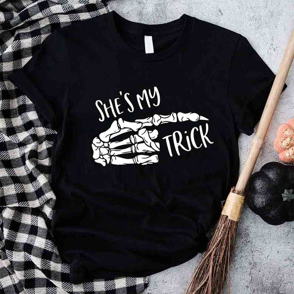 May include matching couple Halloween shirts with skeleton hand graphics, one reading ‘She’s My Trick’ on orange tee and the other reading ‘He’s My Treat’ on black tee – funny spooky couple apparel.