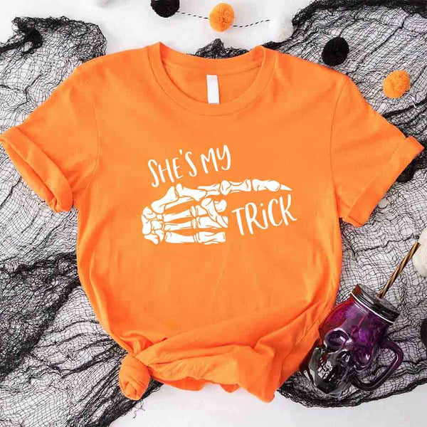 May include matching couple Halloween shirts with skeleton hand graphics, one reading ‘She’s My Trick’ on orange tee and the other reading ‘He’s My Treat’ on black tee – funny spooky couple apparel.