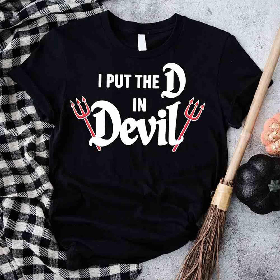 Black t-shirt with 'I Put the D in Devil' text and devil horns design on a checkered cloth background.