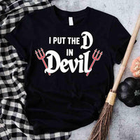 Black t-shirt with 'I Put the D in Devil' text and devil horns design on a checkered cloth background.
