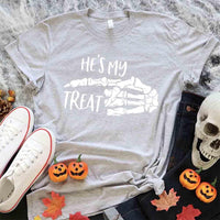 May include matching couple Halloween shirts with skeleton hand graphics, one reading ‘She’s My Trick’ on orange tee and the other reading ‘He’s My Treat’ on black tee – funny spooky couple apparel.