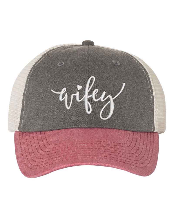 May include an embroidered pigment-dyed trucker hat with mesh back, featuring “Wifey” or “Hubby” text, designed as a casual and stylish gift for spouses or anniversaries.
