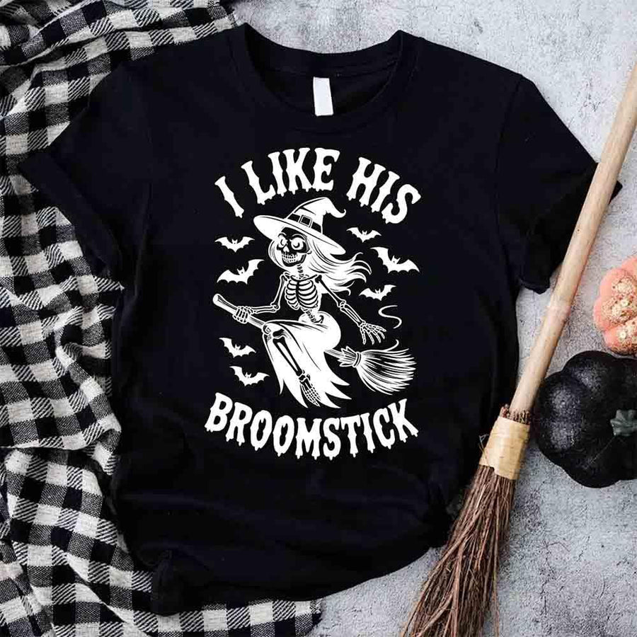 Black t-shirt with skeleton design and text 'I Like His Broomstick' on a checkered fabric background.