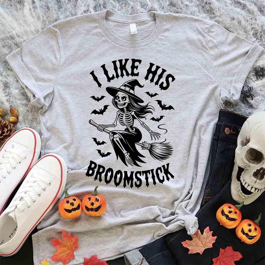 Gray t-shirt with Halloween-themed design featuring a skeleton and text, surrounded by pumpkins and leaves.