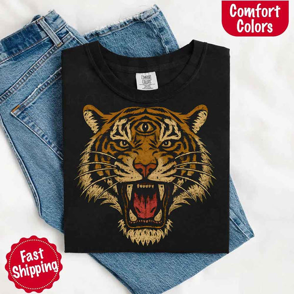 May include a folded Comfort Colors Black T-shirt with a detailed tiger graphic inspired by 90s jungle safari aesthetics, laid over denim jeans for a bold and nostalgic feel.