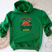 Green hoodie with Thanksgiving-themed design on a textured surface