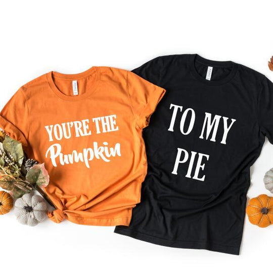 Two Halloween-themed t-shirts, one orange and one black, with humorous sayings on a white background.