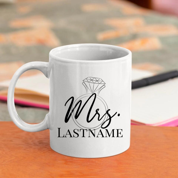 White mug with 'Mrs. Lastname' design on a wooden surface