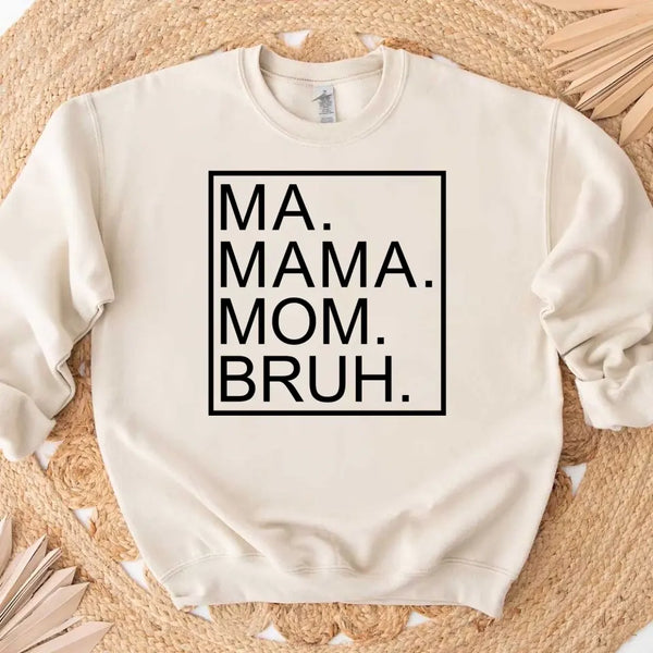 White sweatshirt with text 'MA. MAMA. MOM. BRUH.' on a woven surface
