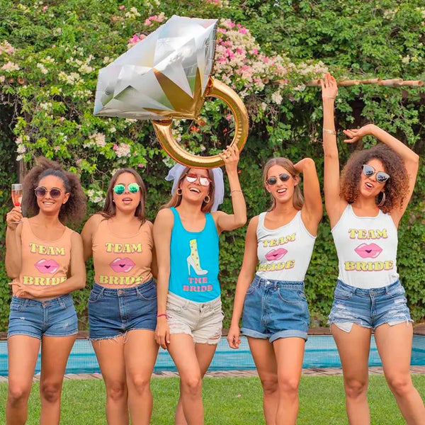 Group of women in matching 'Team Bride' shirts with a large diamond-shaped balloon.