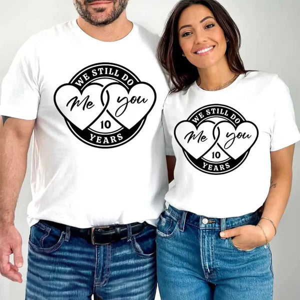 Man and woman wearing white t-shirts with a heart and text design.