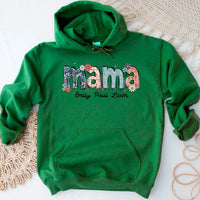 Green hoodie with 'mama' and names printed on it, laid flat on a textured surface.