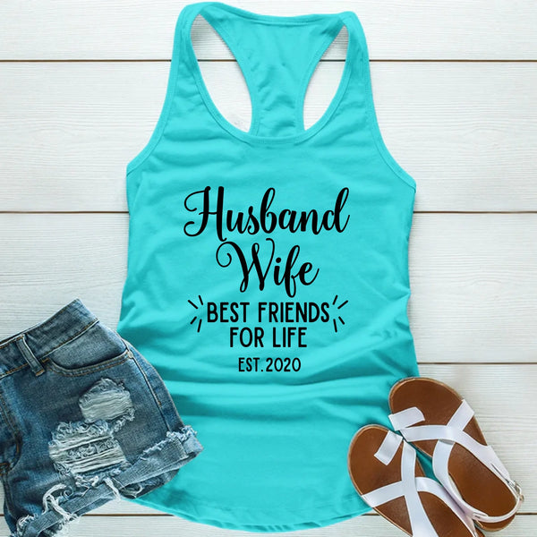 Turquoise tank top with 'Husband Wife Best Friends for Life Est. 2020' text, paired with denim shorts and sandals on a wooden surface.