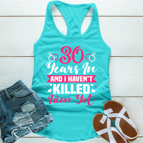 Turquoise tank top with humorous text, paired with denim shorts and sandals on a light wooden background.