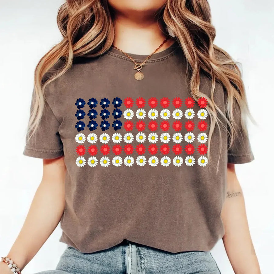 Woman wearing brown tee with American flag made of blue, red, and white daisy flowers