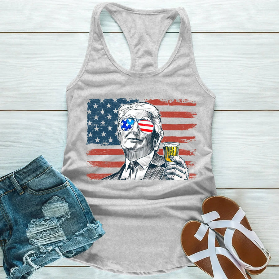 Gray tank top with a graphic design of a person holding a drink, American flag, and sunglasses on a wooden surface.
