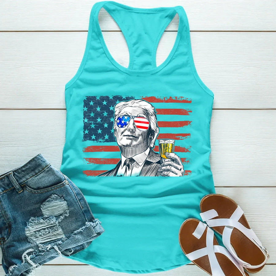 Turquoise tank top with graphic design of a person holding a drink, American flag, and denim shorts on a wooden surface.