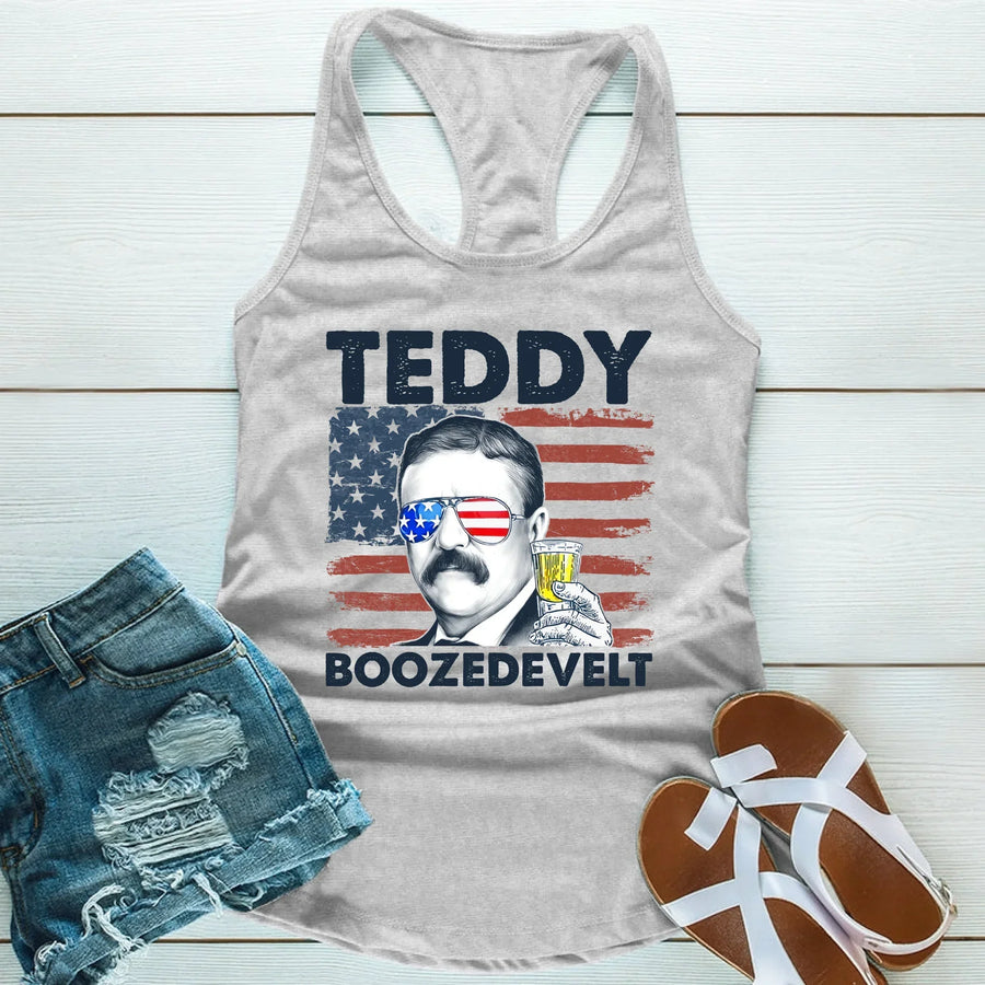Gray tank top with a graphic of Teddy Roosevelt and text, paired with denim shorts and sandals on a wooden surface.