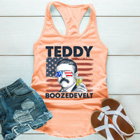 Peach tank top with 'TEDDY BOOZEDEVIL' graphic on a wooden surface with shorts and sandals.