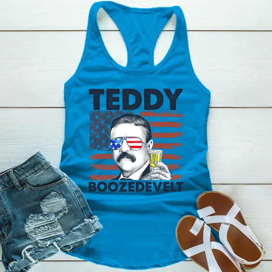 Blue tank top with a graphic of Theodore Roosevelt and text, paired with denim shorts and sandals on a wooden surface.
