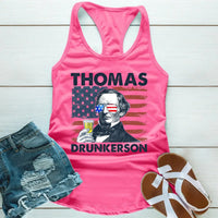 Pink tank top with graphic design and denim shorts on a wooden surface