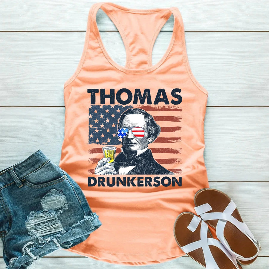 Peach tank top with graphic design and accessories on a wooden surface